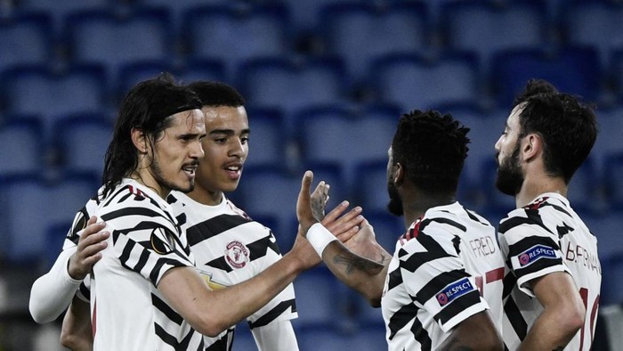 Manchester Uniteds Uruguayan forward Edinson Cavani (L) celebrates with teammates after scoring a goal during the UEFA Europa League semi-final second leg football match between AS Roma and Manchester United at the Olympic Stadium in Rome, on May 6, 2021. (Photo by Filippo MONTEFORTE / AFP)