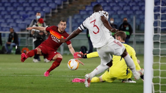 Romas Henrikh Mkhitaryan, left, attempts a shot at goal and misses in front of Manchester Uniteds goalkeeper David de Gea, center, and Manchester Uniteds Eric Bailly during the Europa League semifinal, second leg soccer match between Roma and Manchester United at Romes Olympic stadium, Italy, Thursday, May 6, 2021. (AP Photo/Alessandra Tarantino)