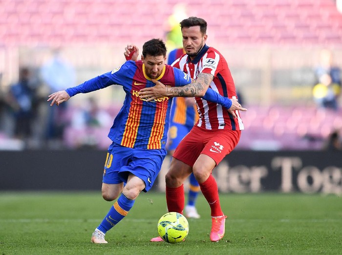 BARCELONA, SPAIN - MAY 08: Lionel Messi of FC Barcelona and Sauel Niguez of Atletico Madrid  battle for the ball  during the La Liga Santander match between FC Barcelona and Atletico de Madrid at Camp Nou on May 08, 2021 in Barcelona, Spain. Sporting stadiums around Spain remain under strict restrictions due to the Coronavirus Pandemic as Government social distancing laws prohibit fans inside venues resulting in games being played behind closed doors. (Photo by David Ramos/Getty Images)