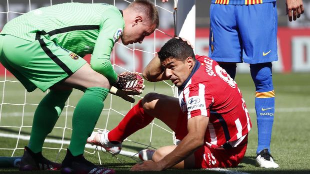 Barcelona's goalkeeper Marc-Andre ter Stegen, left, helps Atletico Madrid's Luis Suarez during the Spanish La Liga soccer match between FC Barcelona and Atletico Madrid at the Camp Nou stadium in Barcelona, Spain, Saturday, May 8, 2021. (AP Photo/Joan Monfort)