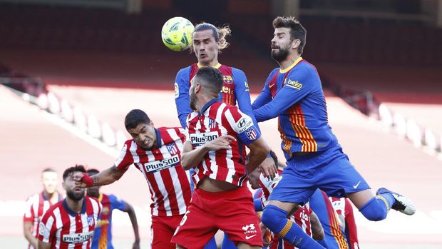 Barcelona's Antoine Griezmann, top left, heads the ball past Atletico Madrid's Koke, center, and Atletico Madrid's Luis Suarez, left, during the Spanish La Liga soccer match between FC Barcelona and Atletico Madrid at the Camp Nou stadium in Barcelona, Spain, Saturday, May 8, 2021. (AP Photo/Joan Monfort)