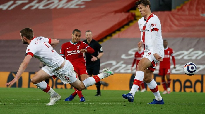 LIVERPOOL, ENGLAND - MAY 08: Thiago of Liverpool scores their sides second goal whilst under pressure from Jack Stephens and Jannik Vestergaard of Southampton during the Premier League match between Liverpool and Southampton at Anfield on May 08, 2021 in Liverpool, England. Sporting stadiums around the UK remain under strict restrictions due to the Coronavirus Pandemic as Government social distancing laws prohibit fans inside venues resulting in games being played behind closed doors. (Photo by Phil Noble - Pool/Getty Images)
