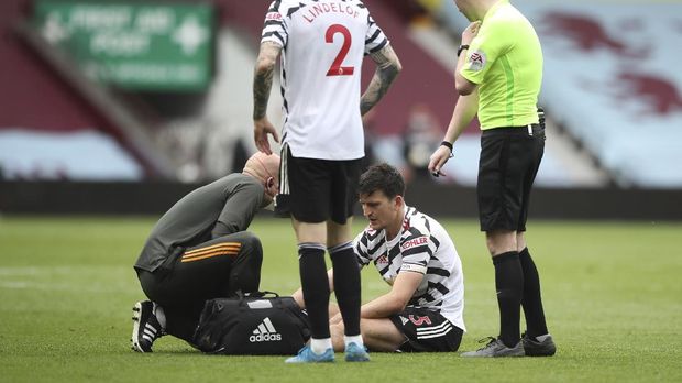 Manchester United's Harry Maguire receives medical treatment during the English Premier League soccer match between Aston Villa and Manchester United at Villa Park in Birmingham, England, Sunday, May 9, 2021. (Nick Potts/Pool via AP)