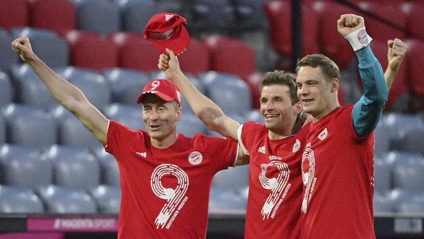 Bayern's Robert Lewandowski, left, Bayern's Thomas Mueller, centre, and Bayern's goalkeeper Manuel Neuer celebrate at the end of the German Bundesliga soccer match between Bayern Munich and Borussia Moenchengladbach at the Allianz Arena stadium in Munich, Germany, Saturday, May 8, 2021.(Peter Kneffel/Pool via AP)