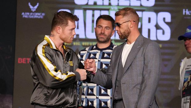 ARLINGTON, TEXAS - MAY 06: Canelo Alvarez and Billy Joe Saunders shake hands with Matchroom Promoter Eddie Hearn looking on during the press conference for Alvarez's WBC and WBA super middleweight titles and Saunders' WBO super middleweight title at Live! by Loews hotel on May 06, 2021 in Arlington, Texas.   Al Bello/Getty Images/AFP (Photo by AL BELLO / GETTY IMAGES NORTH AMERICA / Getty Images via AFP)