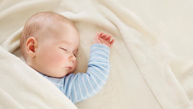 little boy sleeping on soft white blanket