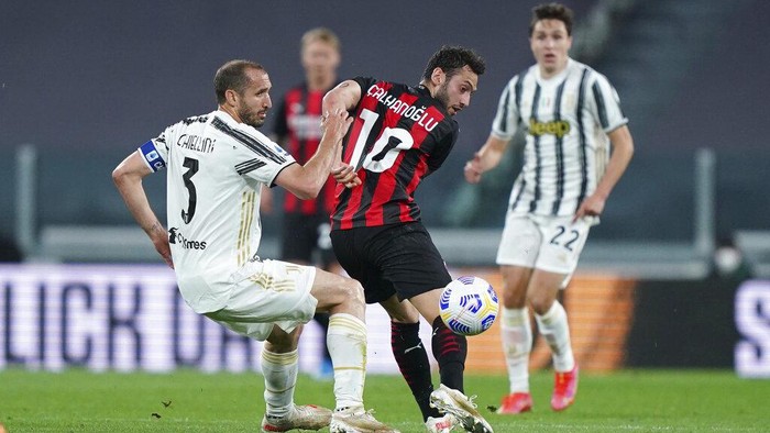 Juventus Giorgio Chiellini, left, and Milans Hakan Calhanoglu in action during the Italian Serie A soccer match between Juventus and Milan, at the Juventus Stadium, in Turin, Italy, Sunday, May 9, 2021. (Spada/LaPresse via AP)