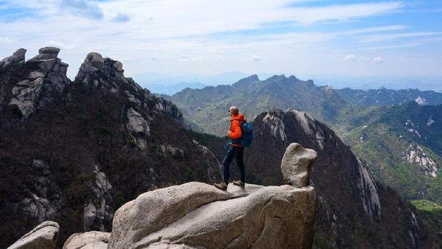 Backpacker is enjoying a weekend in nature hiking at Bukhansan National Park near Seoul, Korea.