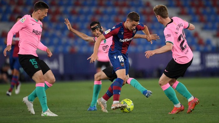 VALENCIA, SPAIN - MAY 11: Frutos of Levante UD is tackled by Clement Lenglet, Sergio Busquets and Frenkie de Jong of Barcelona during the La Liga Santander match between Levante UD and FC Barcelona at Ciutat de Valencia Stadium on May 11, 2021 in Valencia, Spain. Sporting stadiums around Spain remain under strict restrictions due to the Coronavirus Pandemic as Government social distancing laws prohibit fans inside venues resulting in games being played behind closed doors. (Photo by Alex Caparros/Getty Images)