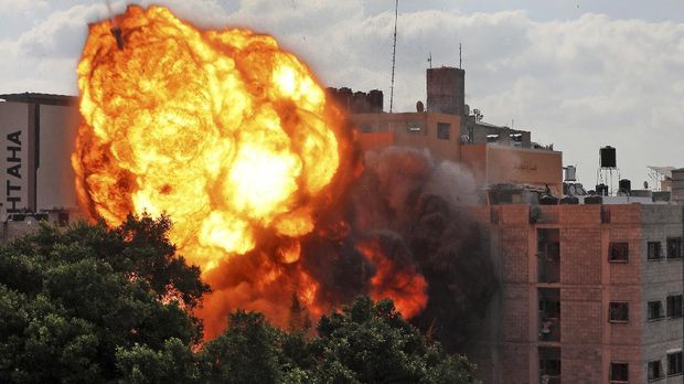 A picture taken on March 13, 2021 shows a ball of fire engulfing the Al-Walid building which was destroyed in an Israeli airstrike on Gaza city early in the morning. - The Israeli army has launched hundreds of air strikes on the Gaza Strip since the begining of the week, while Palestinian militants have launched more than 1,200 rockets, according to Israel's army, in some of the worst violence in seven years in the area. (Photo by - / AFP)