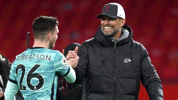 Liverpool's manager Jurgen Klopp, right, shakes hands with Liverpool's Andrew Robertson at the end of the English Premier League soccer match between Manchester United and Liverpool, at the Old Trafford stadium in Manchester, England, Thursday, May 13, 2021. (Michael Regan/Pool via AP)
