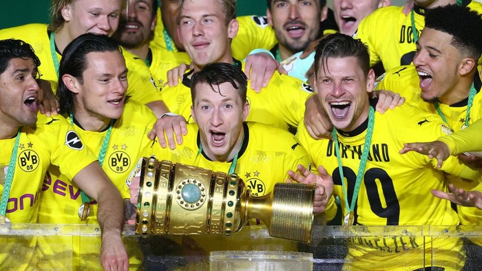 BERLIN, GERMANY - MAY 13: Team captain Marco Reus of Dortmund and teammates celebrate with the trophy after winning the DFB Cup final match between RB Leipzig and Borussia Dortmund at Olympic Stadium on May 13, 2021 in Berlin, Germany. Sporting stadiums around Germany remain under strict restrictions due to the Coronavirus Pandemic as Government social distancing laws prohibit fans inside venues resulting in games being played behind closed doors. (Photo by Martin Rose/Getty Images)