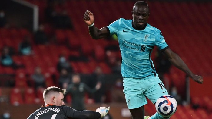 MANCHESTER, ENGLAND - MAY 13: Sadio Mane of Liverpool is challenged by Dean Henderson of Manchester United during the Premier League match between Manchester United and Liverpool at Old Trafford on May 13, 2021 in Manchester, England. Sporting stadiums around the UK remain under strict restrictions due to the Coronavirus Pandemic as Government social distancing laws prohibit fans inside venues resulting in games being played behind closed doors. (Photo by Peter Powell - Pool/Getty Images)