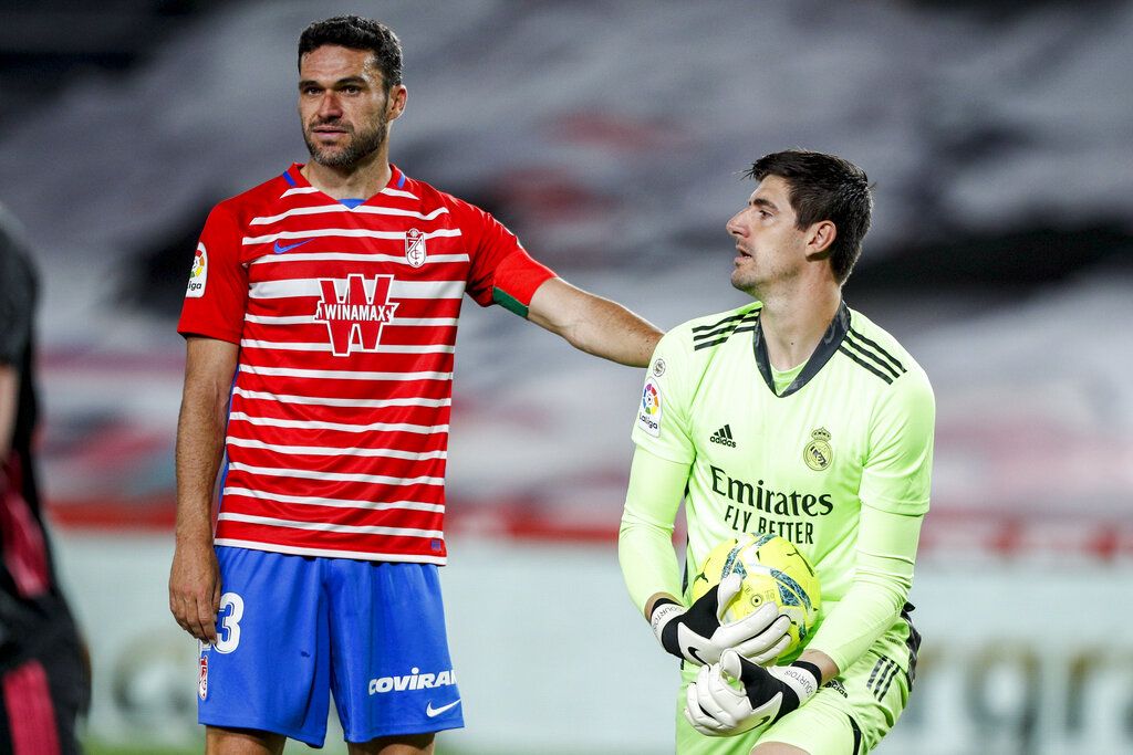 Granada's Jorge Molina, left, stands next to Real Madrid's goalkeeper Thibaut Courtois during the Spanish La Liga soccer match between Granada and Real Madrid at Los Carmenes stadium in Granada, Spain, Thursday, May 13, 2021. (AP Photo/Fermin Rodriguez)