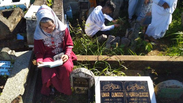 Tradisi Ziarah Kubur Saat Lebaran Masih Dilakukan di Sejumlah Daerah Sejorang perempuan membacakan doa saat ziarah kubur usai melaksanakan shalat Id di Makam Sekar Kedaton, Manado, Sulawesi Utara, Kamis (13/5/2021). Tradisi nyekar makam dilakukan warga keturunan Jawa sebagai bentuk penghormatan bagi orang tua dan leluhurnya. ANTARA FOTO/Adwit B Pramono/hp.