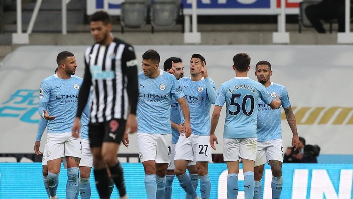 NEWCASTLE UPON TYNE, ENGLAND - MAY 14: Joao Cancelo of Manchester City celebrates with team mates after scoring their sides first goal during the Premier League match between Newcastle United and Manchester City at St. James Park on May 14, 2021 in Newcastle upon Tyne, England. Sporting stadiums around the UK remain under strict restrictions due to the Coronavirus Pandemic as Government social distancing laws prohibit fans inside venues resulting in games being played behind closed doors.  (Photo by Scott Heppell - Pool/Getty Images)