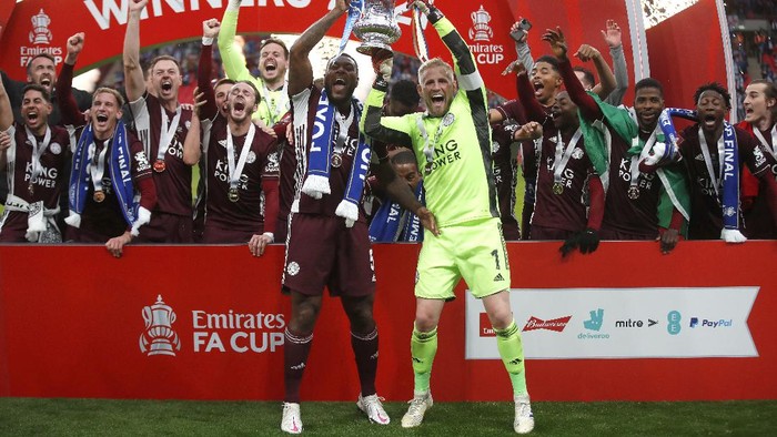 LONDON, ENGLAND - MAY 15: Kasper Schmeichel and Wes Morgan of Leicester City lift the Emirates FA Cup Trophy in celebration with team mates following The Emirates FA Cup Final match between Chelsea and Leicester City at Wembley Stadium on May 15, 2021 in London, England. A limited number of around 21,000 fans, subject to a negative lateral flow test, will be allowed inside Wembley Stadium to watch this years FA Cup Final as part of a pilot event to trial the return of large crowds to UK venues. (Photo by Matt Childs - Pool/Getty Images)
