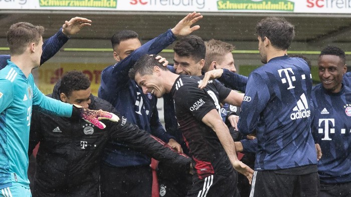 Bayerns Robert Lewandowski, center, celebrates with team mates after scoring during the German Bundesliga soccer match between SC Freiburg and FC Bayern Munich in Freiburg, Germany, Saturday, May 15, 2021. (Tom Weller/dpa via AP)