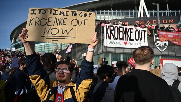 LONDON, ENGLAND - APRIL 23: Arsenal fans hold placards during a protest against the club's owner Stan Kroenke ahead of the Premier League match between Arsenal and Everton, outside Emirates Stadium on April 23, 2021 in London, England. The protest, which takes place amid growing discontent over the running Arsenal FC, was sparked by the club's recent involvement in the European Super League. There was uproar from football fans across the country earlier this week when six major Premier League football clubs, including Arsenal, announced that they were to join the controversial 