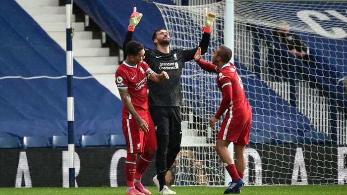 WEST BROMWICH, ENGLAND - MAY 16: Alisson of Liverpool celebrates with team mates (L - R) Roberto Firmino and Thiago after scoring their sides second goal during the Premier League match between West Bromwich Albion and Liverpool at The Hawthorns on May 16, 2021 in West Bromwich, England. Sporting stadiums around the UK remain under strict restrictions due to the Coronavirus Pandemic as Government social distancing laws prohibit fans inside venues resulting in games being played behind closed doors. (Photo by Rui Vieira - Pool/Getty Images)