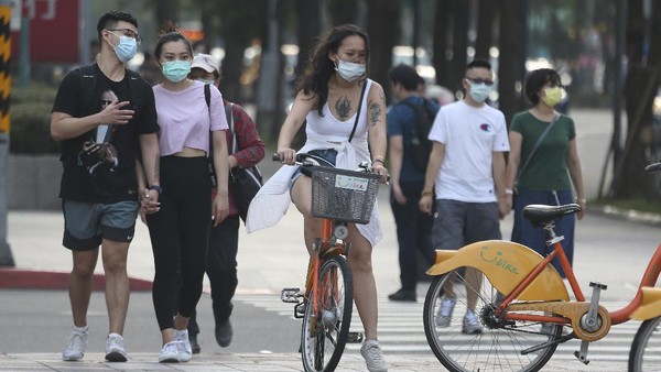 People wear face masks to protect against the spread of the coronavirus after the COVID-19 alert raise to level 3 in Taipei, Taiwan, Saturday, May 15, 2021. Taiwan, which has had enviable success in containing COVID-19, imposed new restrictions in its capital city on Saturday as it battled its worst outbreak since the pandemic began. (AP Photo/Chiang Ying-ying)