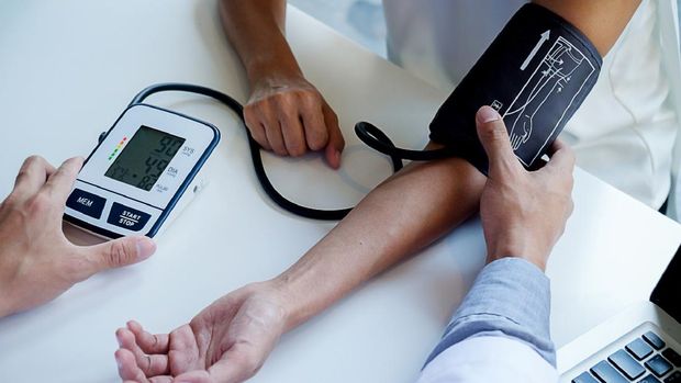 healthcare, hospital and medicine concept - doctor and patient measuring blood pressure.