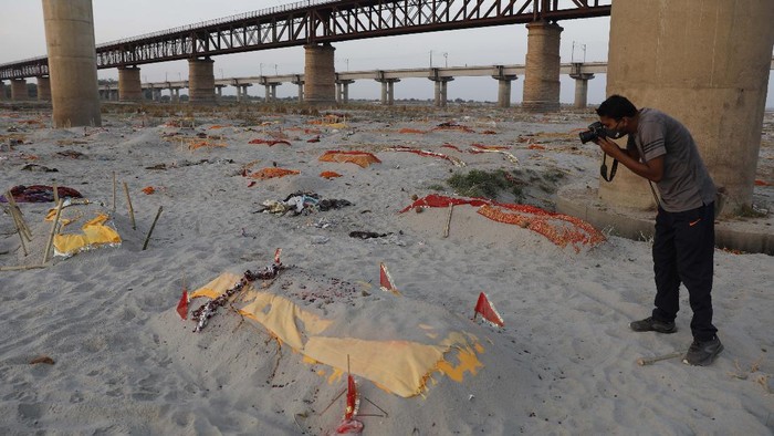 Bodies of suspected Covid-19 victims are seen in shallow graves buried in the sand near a cremation ground on the banks of Ganges River in Prayagraj, India, Saturday, May 15, 2021. (AP Photo/Rajesh Kumar Singh)