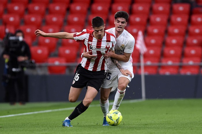 BILBAO, SPAIN - MAY 16: Oihan Sancet of Athletic Club is challenged by Miguel Gutierrez of Real Madrid during the La Liga Santander match between Athletic Club and Real Madrid at Estadio de San Mames on May 16, 2021 in Bilbao, Spain. Sporting stadiums around Spain remain under strict restrictions due to the Coronavirus Pandemic as Government social distancing laws prohibit fans inside venues resulting in games being played behind closed doors.  (Photo by Juan Manuel Serrano Arce/Getty Images)