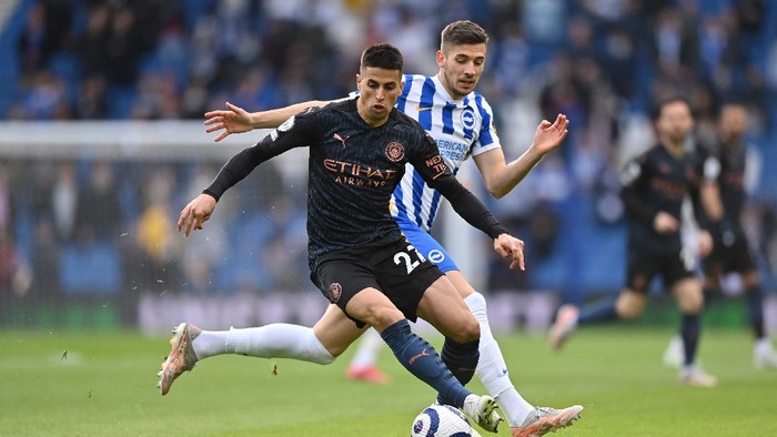 BRIGHTON, ENGLAND - MAY 18: Joao Cancelo of Manchester City turns with the ball whilst under pressure from Jakub Moder of Brighton and Hove Albion during the Premier League match between Brighton & Hove Albion and Manchester City at American Express Community Stadium on May 18, 2021 in Brighton, England. A limited number of fans will be allowed into Premier League stadiums as Coronavirus restrictions begin to ease in the UK following the COVID-19 pandemic. (Photo by Justin Setterfield/Getty Images)