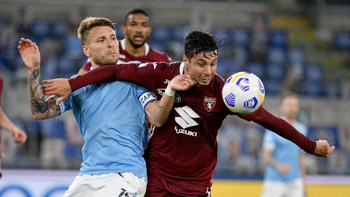 ROME, ITALY - MAY 18: Ciro Immobile of SS Lazio compete for the ball with Armando Izzo of Torino FC during the Serie A match between SS Lazio  and Torino FC at Stadio Olimpico on May 18, 2021 in Rome, Italy. (Photo by Marco Rosi - SS Lazio/Getty Images)