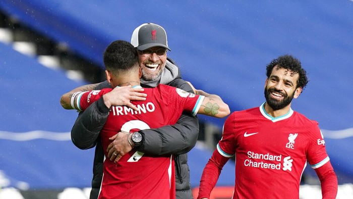 Liverpools manager Jurgen Klopp, center, celebrates with Liverpools Roberto Firmino, front, and Liverpools Mohamed Salah at the end of the English Premier League soccer match between West Bromwich Albion and Liverpool at the Hawthorns stadium in West Bromwich, England, Sunday, May 16, 2021. (Tim Keeton/Pool via AP)