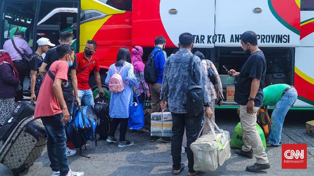 Petugas damkar menyemprot disinfektan kepada bus yang tiba dari daerah di terminal Kp Rambutan, Rabu, 19/5. CNN Indonesia/Adi Maulana Ibrahim