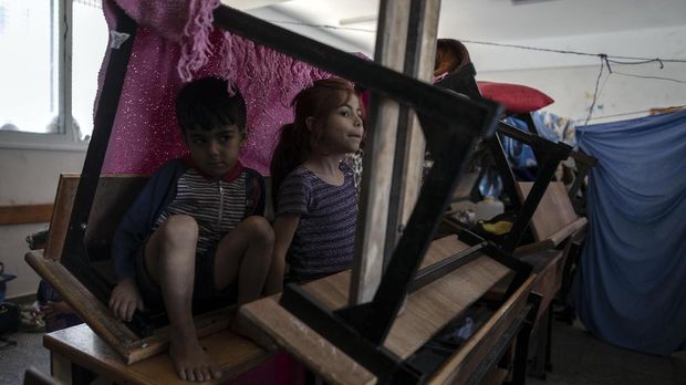 Palestinians take shelter at a school run by the U.N. after fleeing heavy Israeli missile strikes in the outskirts of Gaza City, Wednesday, May 19, 2021. The Gaza Strip's already feeble health system is being brought to its knees by the fourth war in just over a decade. At the school, no one wore a mask or could do any social distancing in the cramped quarters. (AP Photo/Khalil Hamra)