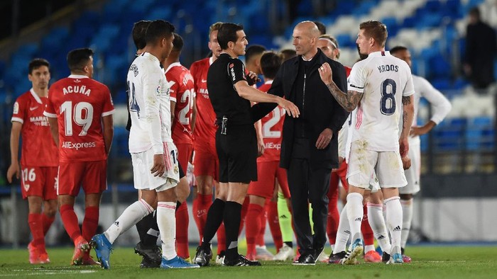 MADRID, SPAIN - MAY 09: Zinedine Zidane, Head Coach of Real Madrid interacts with Referee Juan Martinez Munuera after the La Liga Santander match between Real Madrid and Sevilla FC at Estadio Alfredo Di Stefano on May 09, 2021 in Madrid, Spain. Sporting stadiums around Spain remain under strict restrictions due to the Coronavirus Pandemic as Government social distancing laws prohibit fans inside venues resulting in games being played behind closed doors. (Photo by Denis Doyle/Getty Images)