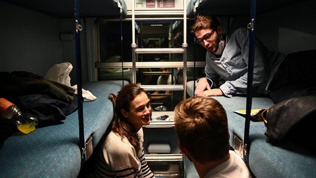 Travelers speak together in a sleeper car of the  Paris-Nice night train, between Paris and Nice, on May 20, 2021 on the day it returns to service after being stopped since December 2017. (Photo by Anne-Christine POUJOULAT / AFP)