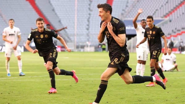 MUNICH, GERMANY - MAY 22: Robert Lewandowski of FC Bayern Muenchen celebrates after scoring their sides fifth goal, scoring his 41st league goal, breaking the record for the most goals scored in a Bundesliga season during the Bundesliga match between FC Bayern Muenchen and FC Augsburg at Allianz Arena on May 22, 2021 in Munich, Germany. After the Bavarian cabinet decided on first relaxations for outdoor events, the current Corona situation allows FC Bayern to have its last match of the season in front of 250 spectators in the Allianz Arena. Of these, 100 tickets are given to people from the health sector selected by the Ministry of Health. (Photo by Alexander Hassenstein/Getty Images)