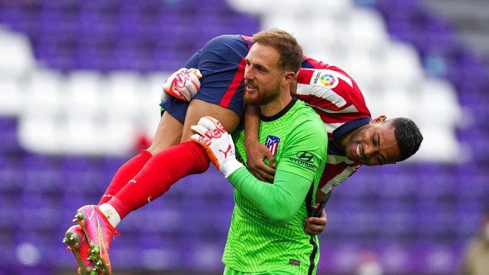 Atletico Madrids goalkeeper Jan Oblak celebrates with teammate Renan Lodi, top, at the end of the Spanish La Liga soccer match between Atletico Madrid and Valladolid at the Jose Zorrilla stadium in Valladolid, Spain, Saturday, May 22, 2021. Atletico won 2-1 and clinches its 11th Spanish La Liga title. (AP Photo/Manu Fernandez)