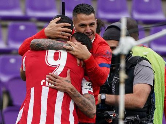 Atletico Madrid's Uruguayan forward Luis Suarez (L) celebrates with teammates after scoring during the Spanish league football match Real Valladolid FC against Club Atletico de Madrid at the Jose Zorilla stadium in Valladolid on May 22, 2021. (Photo by CESAR MANSO / AFP)