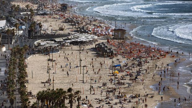 People enjoy the beach front in Tel Aviv, Israel, Saturday, May 22, 2021. A cease-fire took effect early Friday after 11 days of heavy fighting between Israel and Gaza's militant Hamas rulers that was ignited by protests and clashes in Jerusalem. (AP Photo/Oded Balilty)