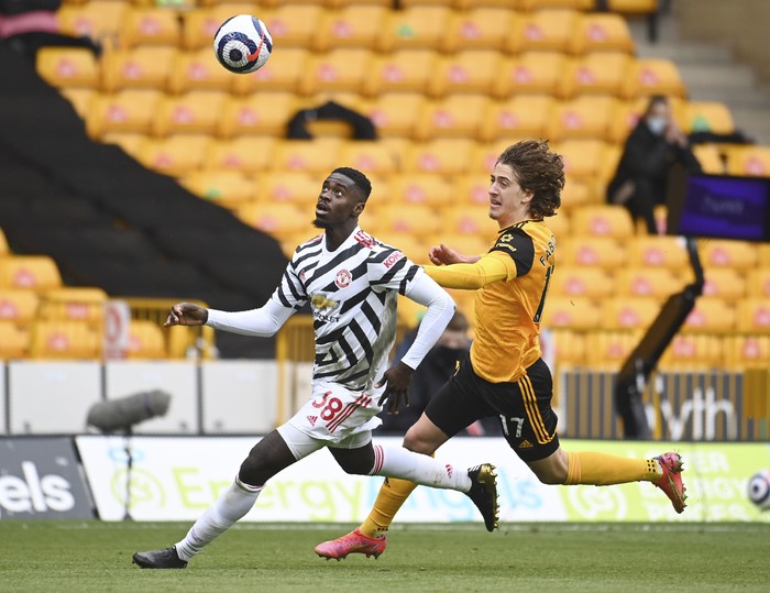 Wolverhampton Wanderers Fabio Silva, right, and Manchester Uniteds Bruno Fernandes challenge for the ball during the English Premier League soccer match between Wolverhampton Wanderers and Manchester United at the Molineux Stadium in Wolverhampton, England, Sunday, May 23, 2021. (Andy Rain/Pool via AP)