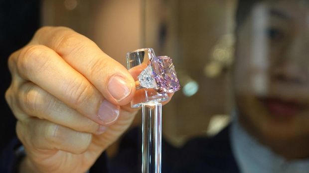 An employee poses with a 15.81 carat fancy vivid purple pink diamond ring, which is called The Sakura Diamond, during a preview at Christie’s ahead of the upcoming auction, in Hong Kong, China May 6, 2021. REUTERS/Joyce Zhou