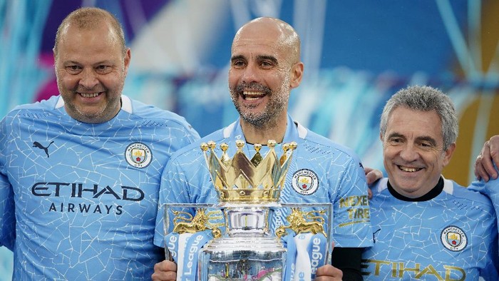 MANCHESTER, ENGLAND - MAY 23: Rodolfo Borrell, Assistant Coach of Manchester City, Pep Guardiola, Manager of Manchester City, and Juanma Lillo, Assistant Manager of Manchester City celebrates with the Premier League Trophy as Manchester City are presented with the Trophy as they win the league following the Premier League match between Manchester City and Everton at Etihad Stadium on May 23, 2021 in Manchester, England. A limited number of fans will be allowed into Premier League stadiums as Coronavirus restrictions begin to ease in the UK. (Photo by Dave Thompson - Pool/Getty Images)