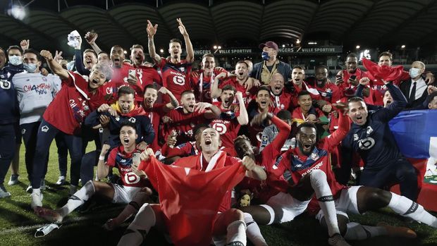 Lille players and coaches celebrate after the French League One soccer match between Angers and Lille at the Raymond Kopa Stadium in Angers, France, Sunday May 23, 2021. Lille won the match 2-1 to clinch the French League One title. (AP Photo/Lewis Joly)