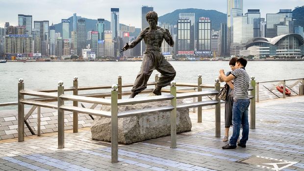 Hong Kong, Hong Kong SAR -November 09, 2014: Young Asian couple at the Bruce Lee statue in the Avenue of Stars in Hong Kong.