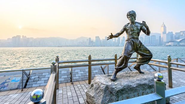 Hong Kong, Hong Kong SAR -November 09, 2014: Young Asian couple at the Bruce Lee statue in the Avenue of Stars in Hong Kong.