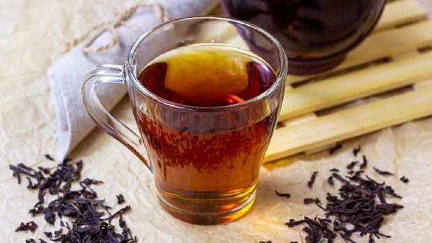 Fresh organic aromatic black tea in the glass cup on light background. (iStockphoto/Ildar Imashev)