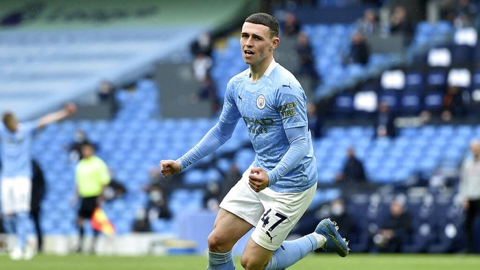 Manchester Citys Phil Foden celebrates scoring his sides third goal during the English Premier League soccer match between Manchester City and Everton at the Etihad stadium in Manchester, Sunday, May 23, 2021.(Peter Powel/Pool via AP)