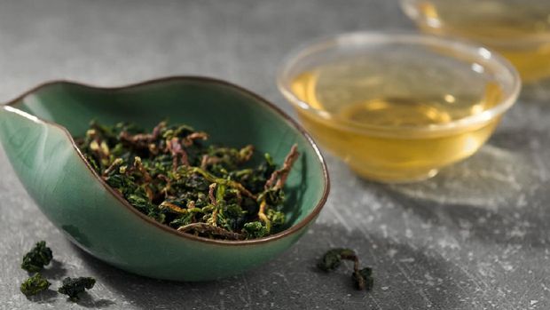 Dry tea leaves and hot drink in asian style cups. Oolong chinese tea in cha he. (iStockphoto/ninelutsk)