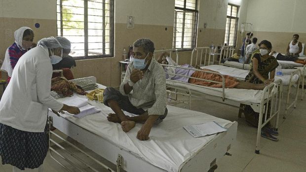 penyakit jamur hitam di india A doctor checks the medical reports as she examines the patients who recovered from Covid-19 coronavirus and now infected with Black Fungus, a deadly fungal infection at a ward of a government hospital in Hyderabad on May 21, 2021. (Photo by NOAH SEELAM / AFP)