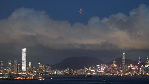 The moon rises over the Victoria Harbour in Hong Kong, Wednesday, May 26, 2021. The first total lunar eclipse in more than two years coincides with a supermoon this week for quite a cosmic show. (AP Photo/Kin Cheung)